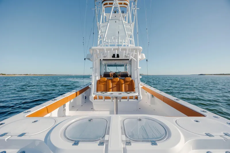 Slide: The Image of 2024 Invincible 46 Pilothouse boat on open water, showcasing sleek design and spacious deck. - 22