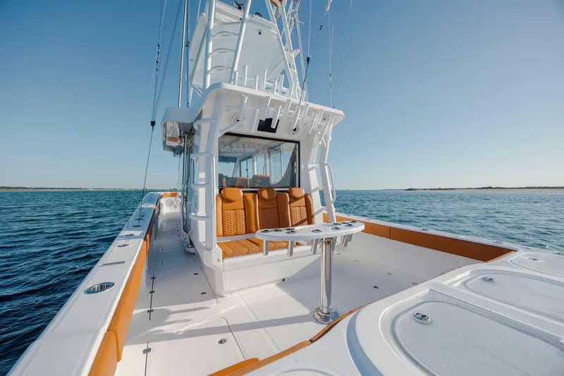 Slide: The Image of 2024 Invincible 46 Pilothouse boat on open water, featuring sleek design and spacious deck. - 24