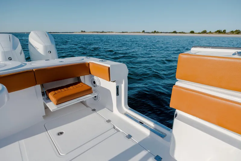 Slide: The Image of 2024 Invincible 46 Pilothouse boat interior with orange seating, ocean view. - 28