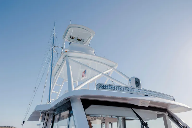 Slide: The Image of 2024 Invincible 46 Pilothouse boat with sleek design and advanced features against clear sky. - 36
