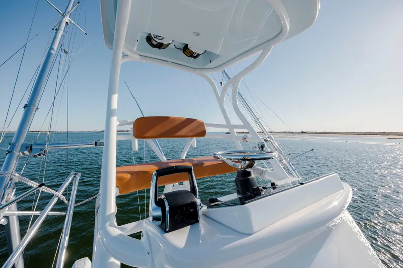 Slide: The Image of 2024 Invincible 46 Pilothouse helm with ocean view, featuring modern controls and seating. - 48