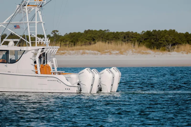 Slide: The Image of 2024 Invincible 46 Pilothouse boat with triple outboard engines on calm water. - 52