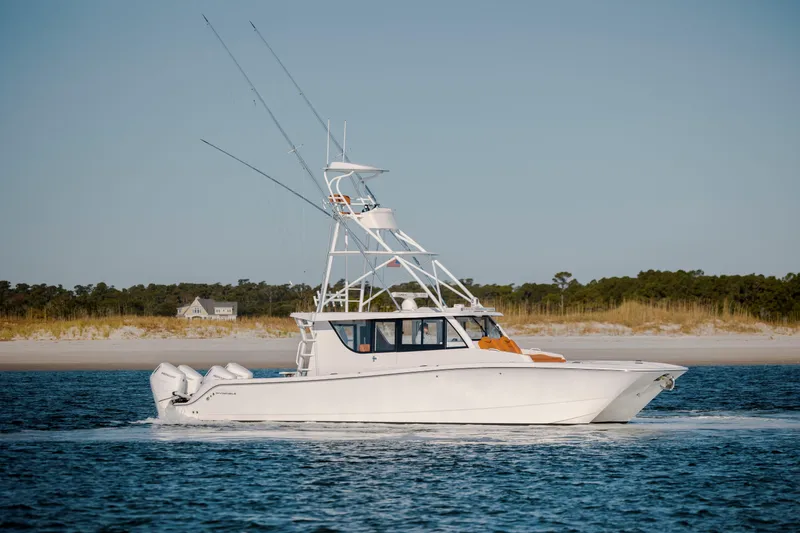 Slide: The Image of 2024 Invincible 46 Pilothouse boat cruising near sandy shoreline. - 7