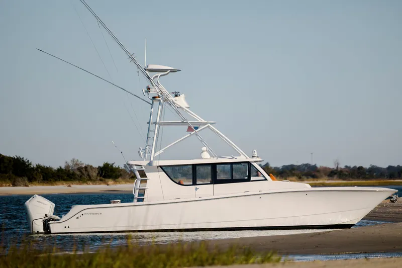 Slide: The Image of 2024 Invincible 46 Pilothouse boat on calm water near shoreline. - 8
