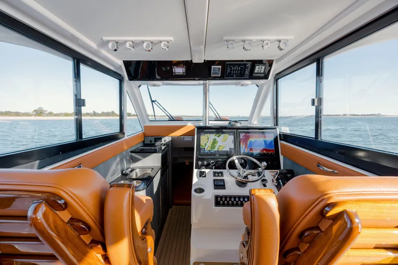 Slide: The Image of 2024 Invincible 46 Pilothouse interior with modern navigation equipment and luxurious seating. - 9
