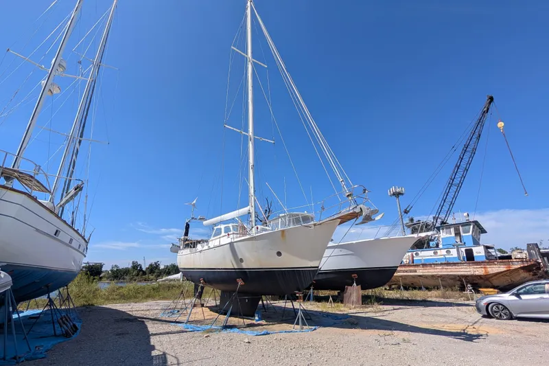 The Image of Bruce Bingham Custom 47 Steel Hull sailboat on land, 1992 model, with clear blue sky. - 0