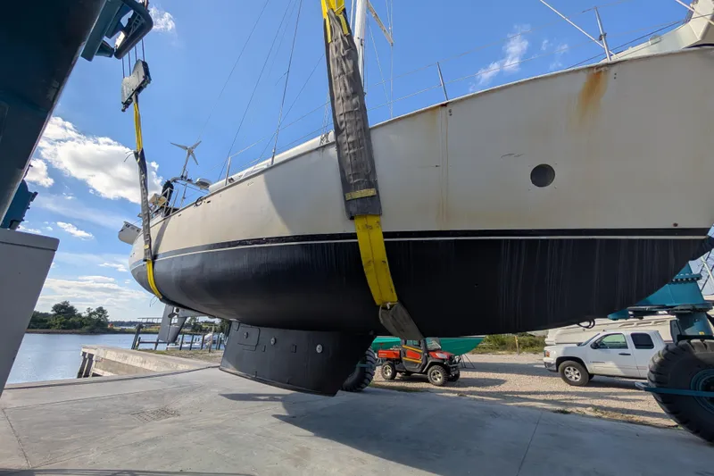 Slide: The Image of Bruce Bingham Custom 47 Steel Hull 1992 sailboat being lifted at a marina. - 10