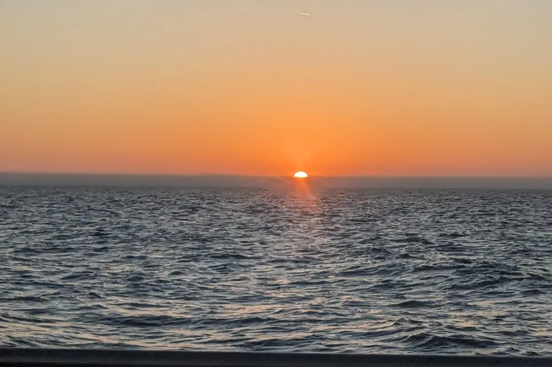 Slide: The Image of Sunset over ocean horizon, viewed from Bruce Bingham Custom 47, Steel Hull 47, 1992. - 22