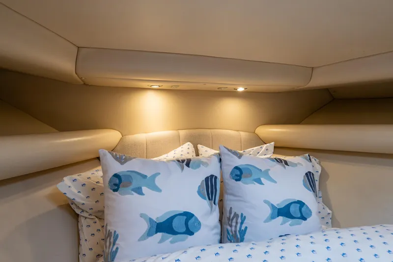 Slide: The Image of Luxurious 2004 Riviera 37 Flybridge cabin with fish-themed pillows and cozy lighting. - 13