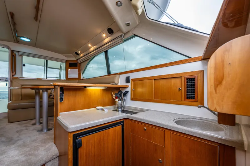 Slide: The Image of Interior of 2004 Riviera 37 Flybridge yacht with modern kitchen and seating area. - 14