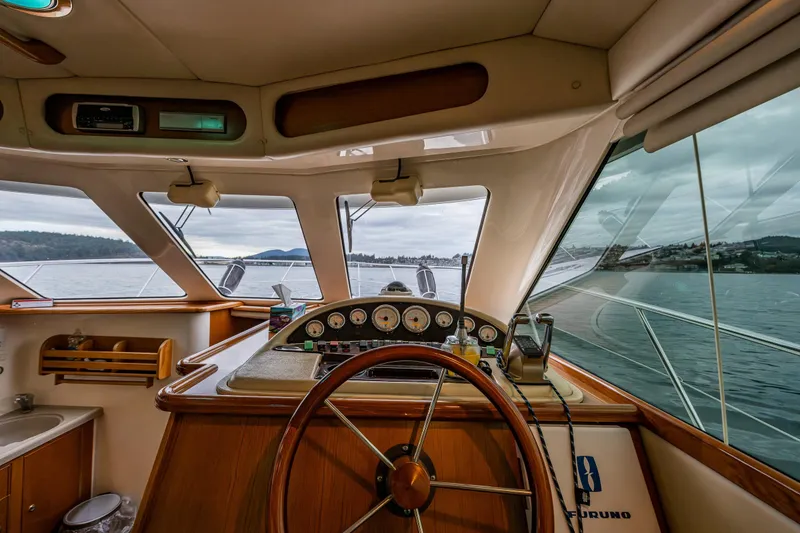 Slide: The Image of Interior view of 2004 Riviera 37 Flybridge yacht helm with panoramic water views. - 17