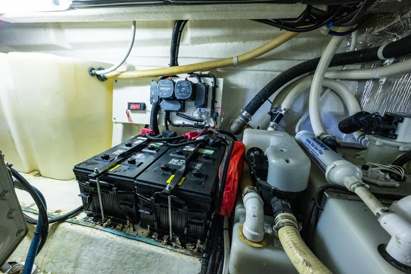 Slide: The Image of Engine room of 2004 Riviera 37 Flybridge with batteries and plumbing components. - 29