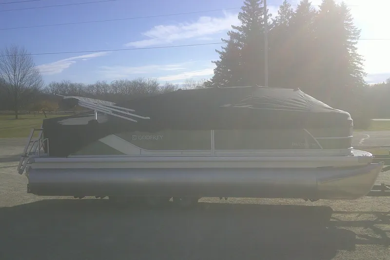 Slide: The Image of 2026 Godfrey Sweetwater 2286 FS pontoon boat covered, parked outdoors on a sunny day. - 16