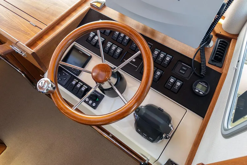 Slide: The Image of Steering wheel and control panel of 2019 Targa 32 boat, featuring wood accents and modern instruments. - 18