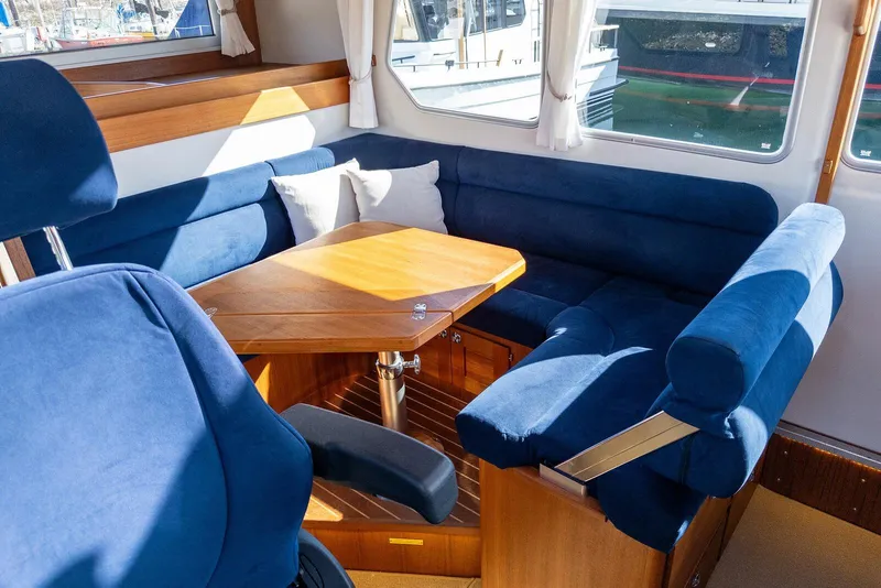 Slide: The Image of Interior of 2019 Targa 32 boat with blue seating and wooden table. - 23