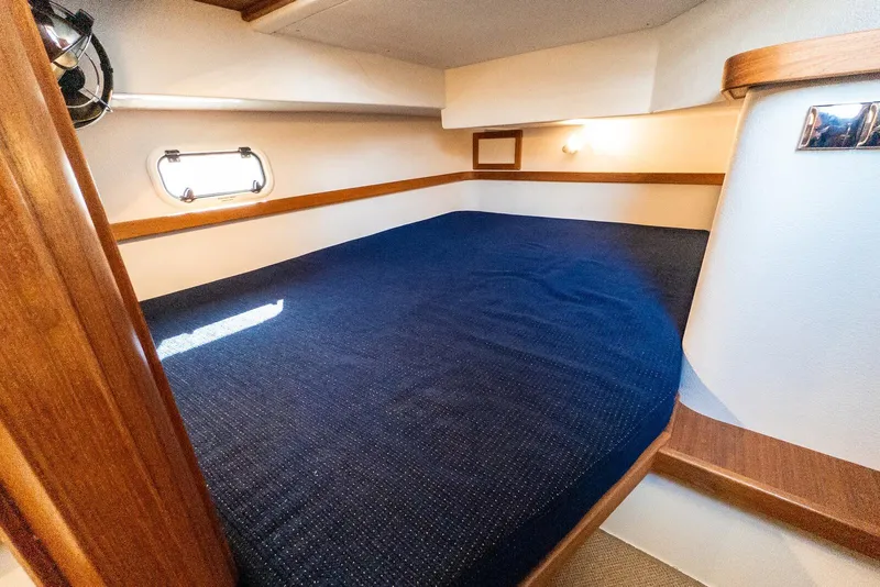 Slide: The Image of Cozy cabin interior of 2019 Targa 32 boat with blue bedding and wooden accents. - 27