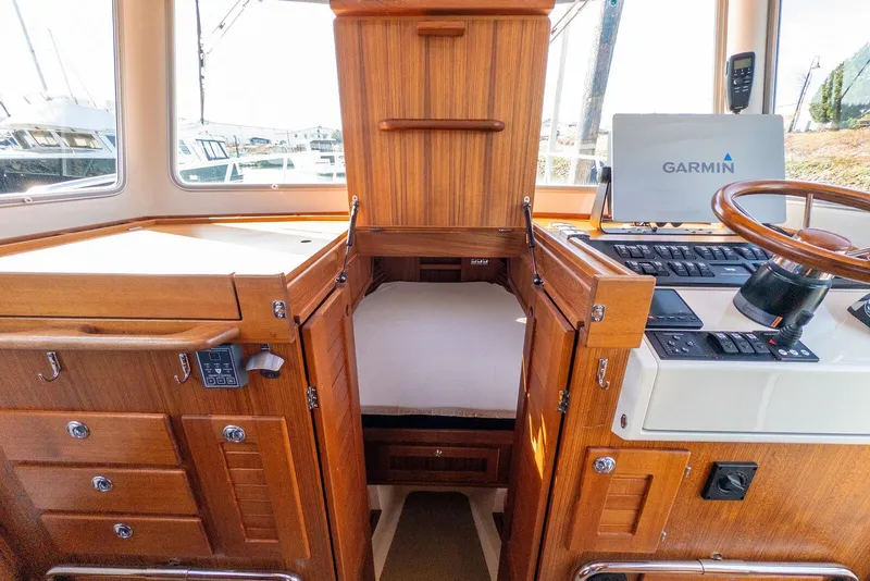 Slide: The Image of 2019 Targa 32 boat interior with Garmin navigation, wooden cabinetry, and cozy sleeping area. - 32