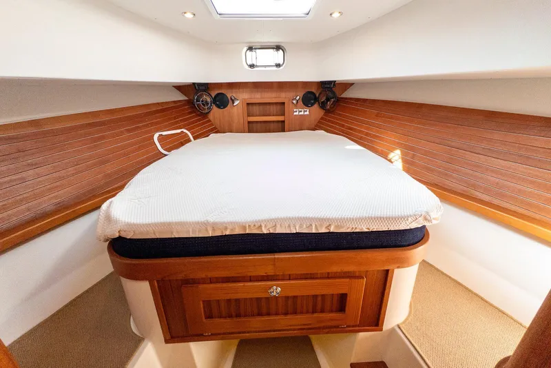 Slide: The Image of Cozy cabin interior of 2019 Targa 32 boat with wooden accents and comfortable bedding. - 33