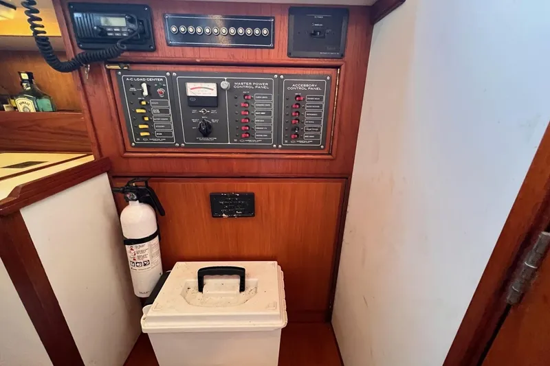 Slide: The Image of Electrical control panel in a 1988 Shannon 28 boat interior with fire extinguisher. - 10