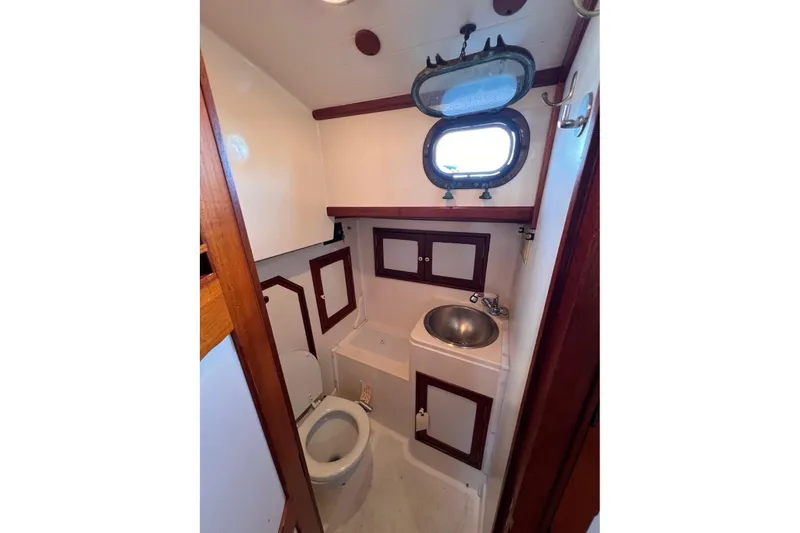 Slide: The Image of Compact bathroom in 1988 Shannon 28 boat with sink, toilet, and porthole window. - 11