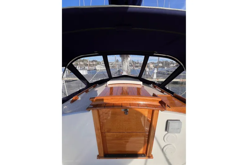 Slide: The Image of 1988 Shannon 28 sailboat cockpit with wooden hatch and marina view. - 13
