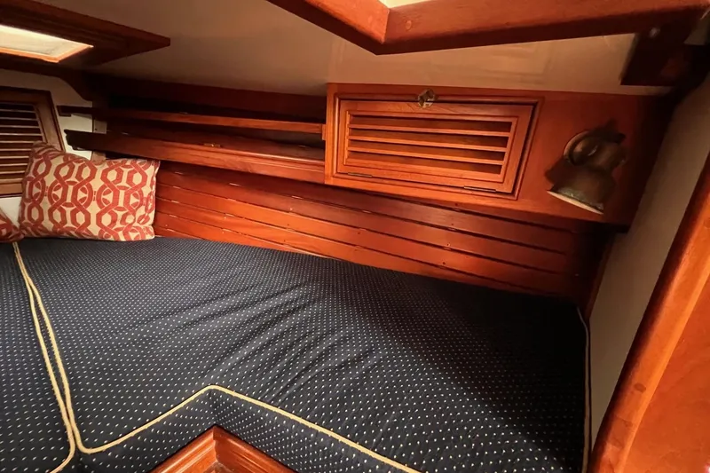 Slide: The Image of Cozy cabin interior of 1988 Shannon 28 sailboat with wooden paneling and patterned cushions. - 5