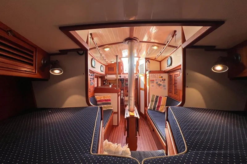 Slide: The Image of Interior of 1988 Shannon 28 sailboat with cozy wooden design and blue upholstery. - 6