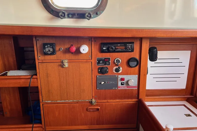 Slide: The Image of 1988 Shannon 28 sailboat control panel with gauges, switches, and radio equipment. - 9