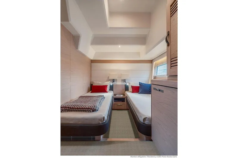 Slide: The Image of Luxurious cabin interior of 2025 Beneteau Grand Trawler 63 with twin beds and modern decor. - 20