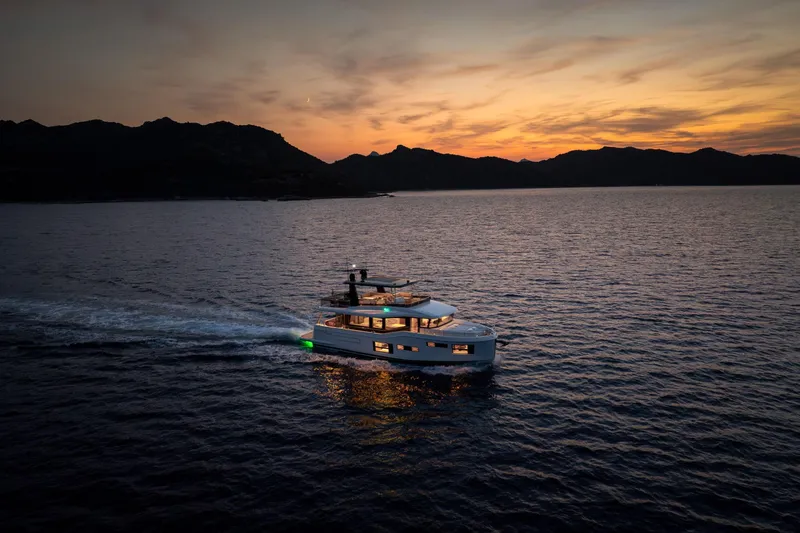 Slide: The Image of 2025 Beneteau Grand Trawler 63 cruising at sunset on serene waters. - 18