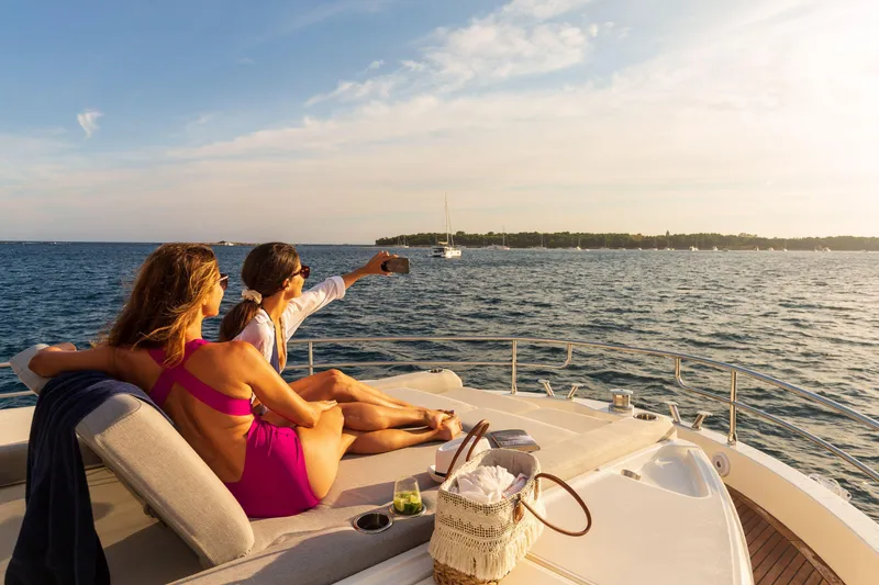 Slide: The Image of Couple relaxing on 2025 Beneteau Grand Trawler 63, enjoying ocean view and taking a selfie. - 27