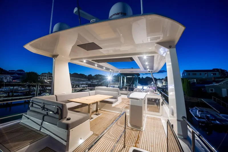 Slide: The Image of Luxurious 2025 Beneteau Grand Trawler 63 yacht deck at dusk, featuring elegant seating and lighting. - 31