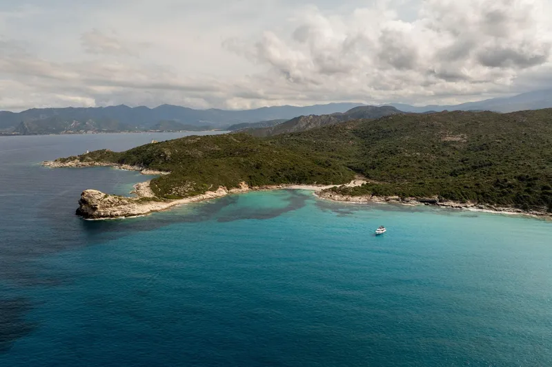 Slide: The Image of Aerial view of Beneteau Grand Trawler 63, 2025, cruising near a scenic coastline. - 38