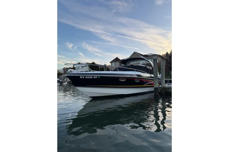 The Image of 2007 Formula 310 Sun Sport boat docked at sunset, reflecting on calm water. - 0
