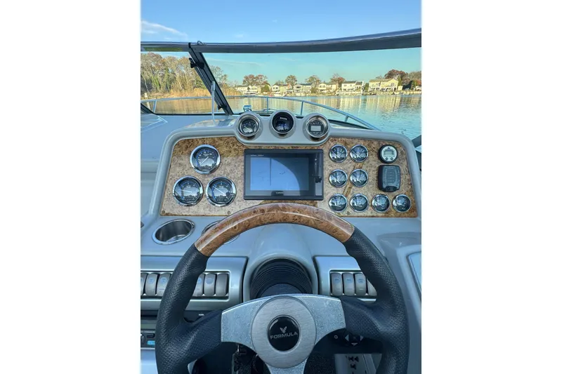 Slide: The Image of 2007 Formula 310 Sun Sport dashboard with gauges and steering wheel, overlooking serene water. - 11