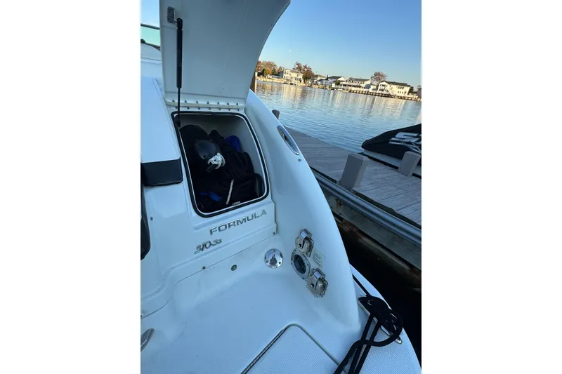 Slide: The Image of 2007 Formula 310 Sun Sport boat docked by a serene waterfront. - 4