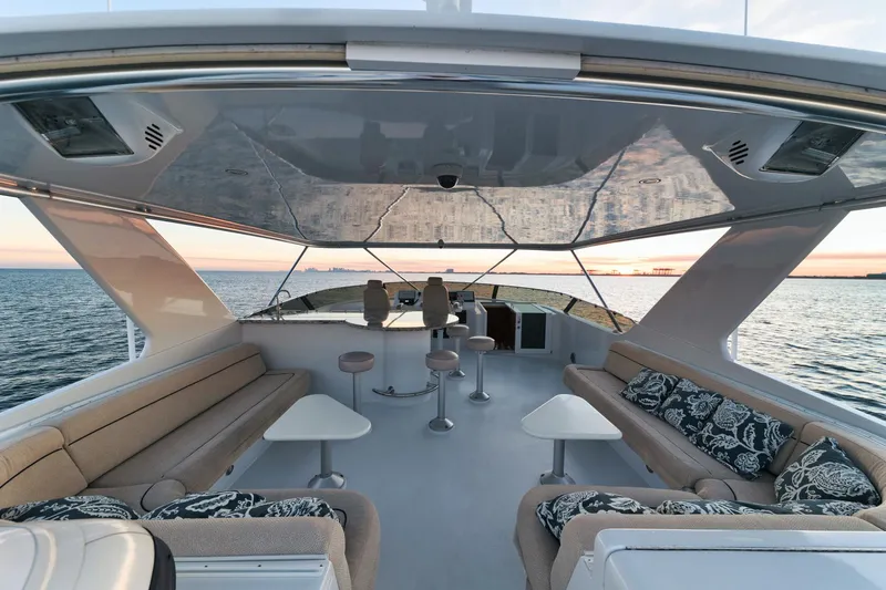 Slide: The Image of Luxurious 2002 Hatteras Motor Yacht deck with seating, ocean view, and sunset backdrop. - 12
