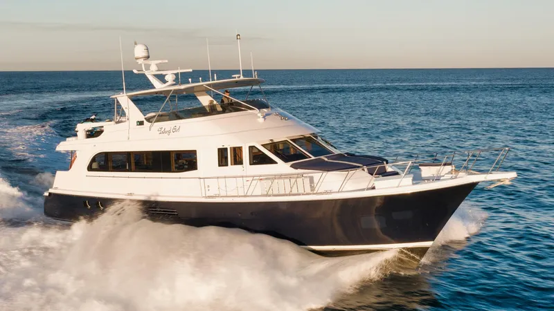 Slide: The Image of 2002 Hatteras Motor Yacht cruising on open water, showcasing sleek design and luxury. - 2