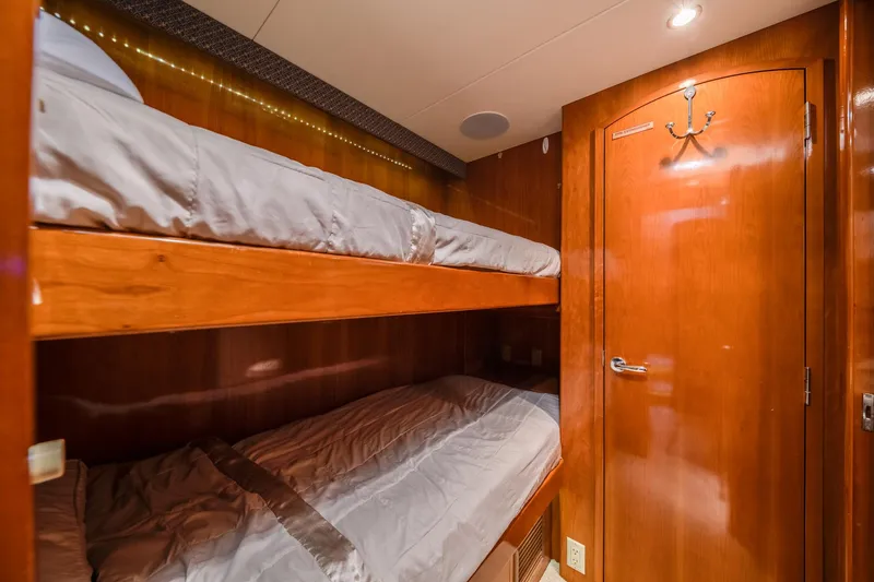 Slide: The Image of Bunk beds in 2002 Hatteras Motor Yacht cabin with wooden interior and cozy lighting. - 32