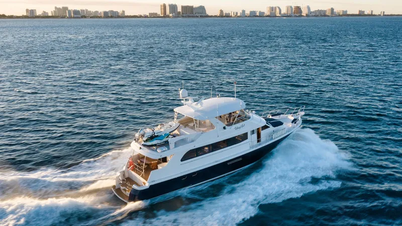 Slide: The Image of 2002 Hatteras Motor Yacht cruising on open water with city skyline in background. - 8