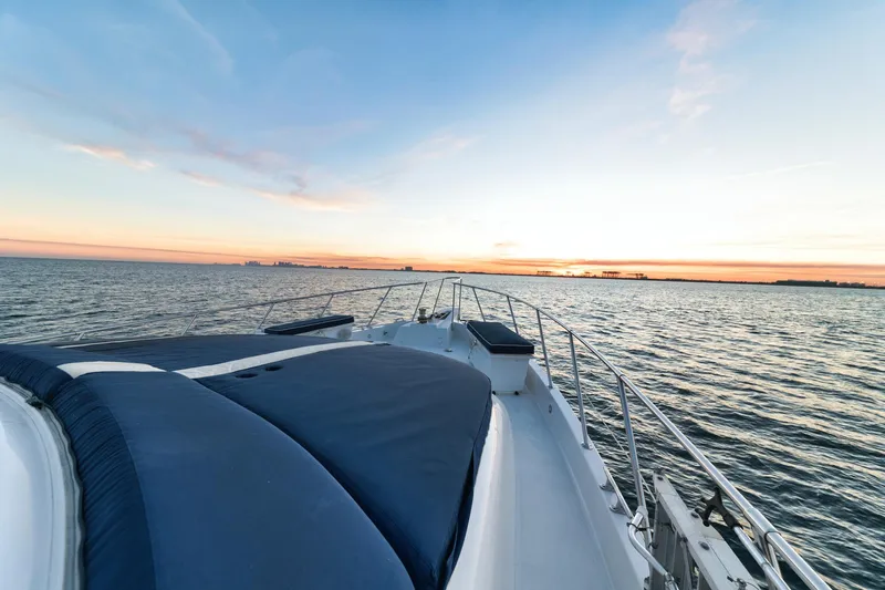 Slide: The Image of 2002 Hatteras Motor Yacht cruising at sunset on calm waters. - 18