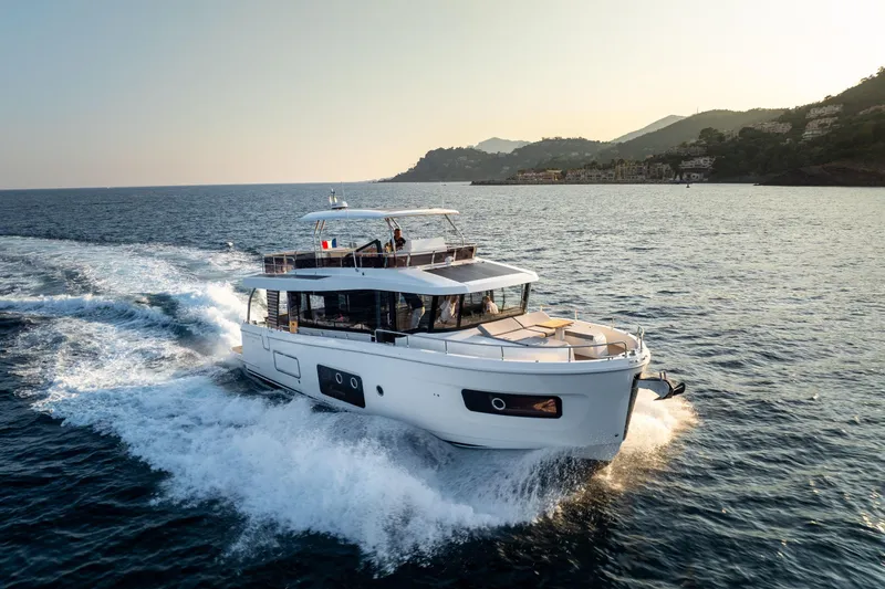 Slide: The Image of 2026 Beneteau Swift Trawler 54 cruising on open sea at sunset. - 13