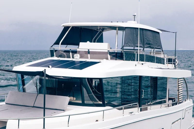 Slide: The Image of 2026 Beneteau Swift Trawler 54 on open water, showcasing modern design and solar panels. - 14