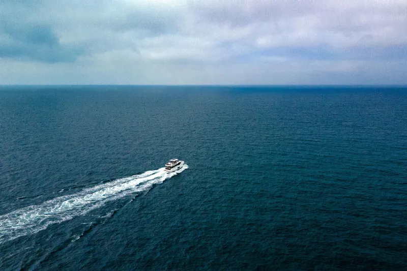 Slide: The Image of Aerial view of 2026 Beneteau Swift Trawler 54 cruising on open sea. - 15