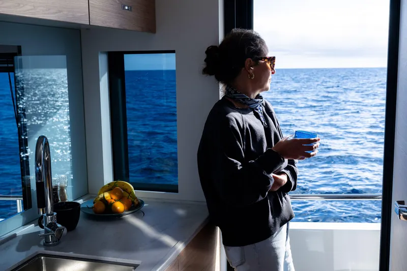 Slide: The Image of Woman enjoying ocean view from 2026 Beneteau Swift Trawler 54 kitchen. - 27