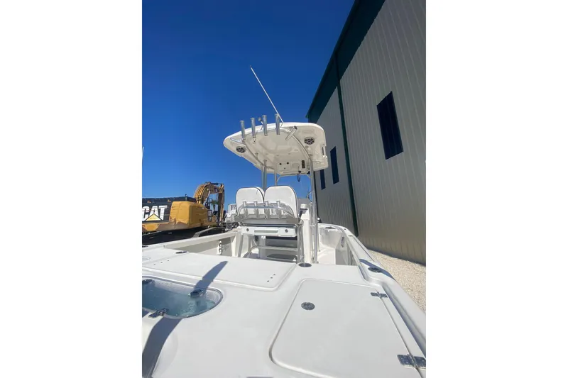 Slide: The Image of 2021 Sea Pro 248 Bay boat with T-top, docked near industrial equipment. - 19