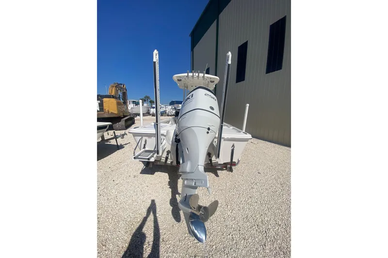 Slide: The Image of 2021 Sea Pro 248 Bay boat with outboard motor, parked outdoors on gravel. - 21