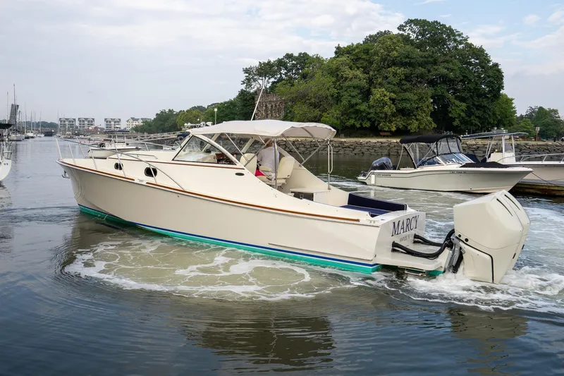 Slide: The Image of 2021 Brooklin Boat Yard 32 Express cruising on a calm river near lush greenery. - 2