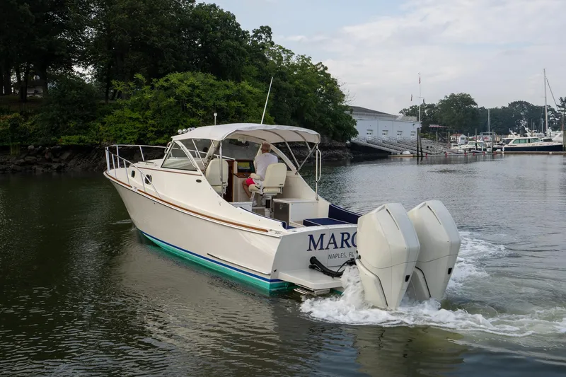 Slide: The Image of 2021 Brooklin Boat Yard 32 Express cruising in a marina with lush greenery. - 3