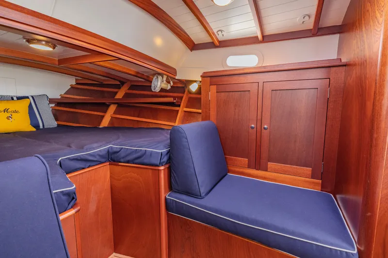 Slide: The Image of Luxurious cabin interior of 2021 Brooklin Boat Yard 32 Express with wooden finish and blue cushions. - 22